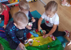 Dzieci podczas zabaw kreatywnych z pomponami.